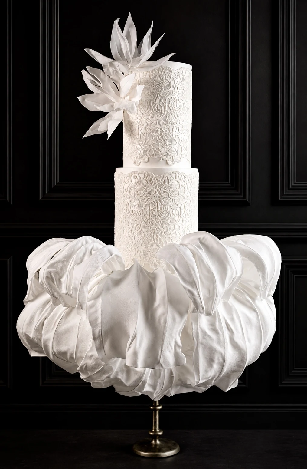 Ivory wedding cake with delicate edible lace and voluminous fabric ruffles